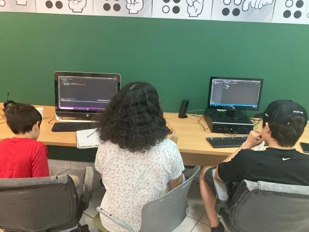 Participantes trabajando frente a computadoras en un taller de edición de video.