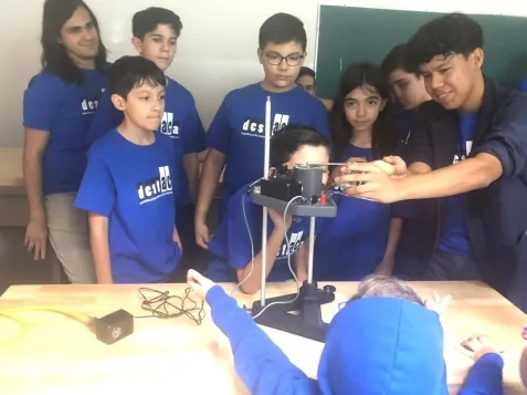 Grupo de participantes observando equipo de laboratorio durante una visita universitaria.
